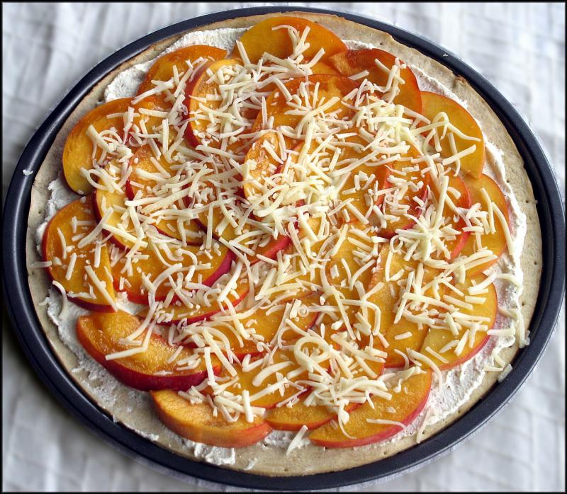 Peach pizza ready for the oven, with ricotta cheese, olive oil, peach slices and shredded white cheddar cheese. JACK CLEMONS PHOTO